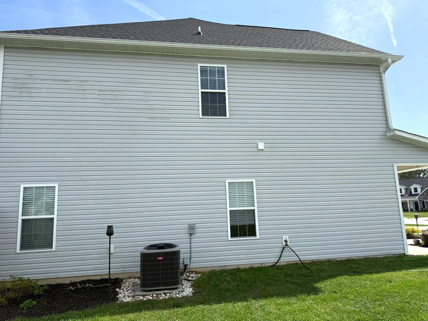Pressure washing revitalizes the exterior of a house, removing dirt and stains from vinyl siding for a clean finish.