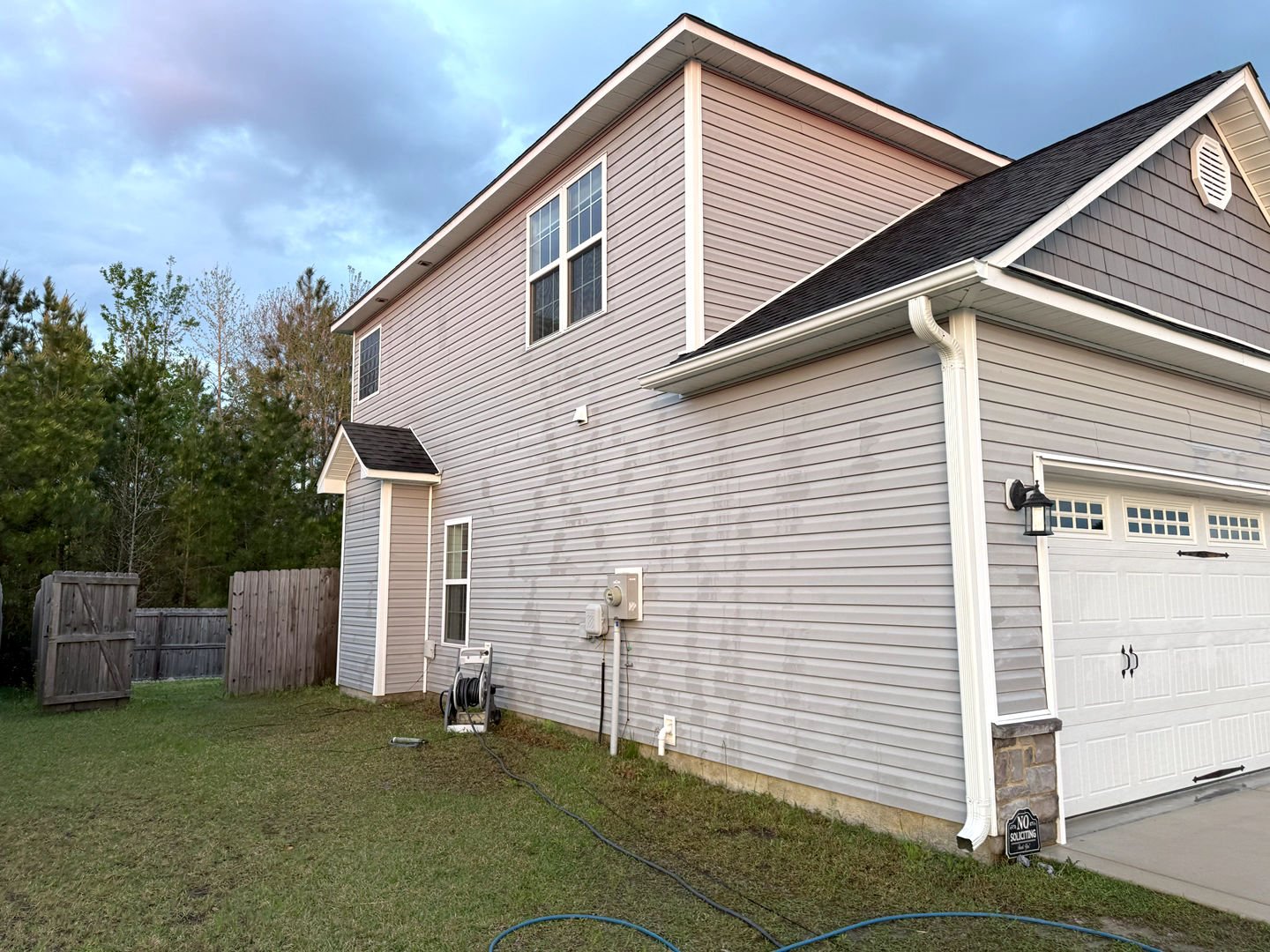 Pressure washing a vinyl siding house, showcasing a clean, refreshed exterior with noticeable dirt removal and improved curb appeal.