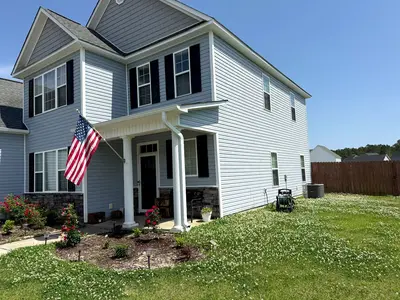 Pressure washing a residential vinyl siding, showcasing a clean, pristine exterior with vibrant colors and curb appeal.