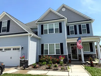 Pressure washing cleaned the exterior of a blue house, enhancing its curb appeal and restoring its shine.