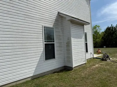 Freshly pressure washed house siding showing dramatic removal of dirt and grime, enhancing curb appeal.