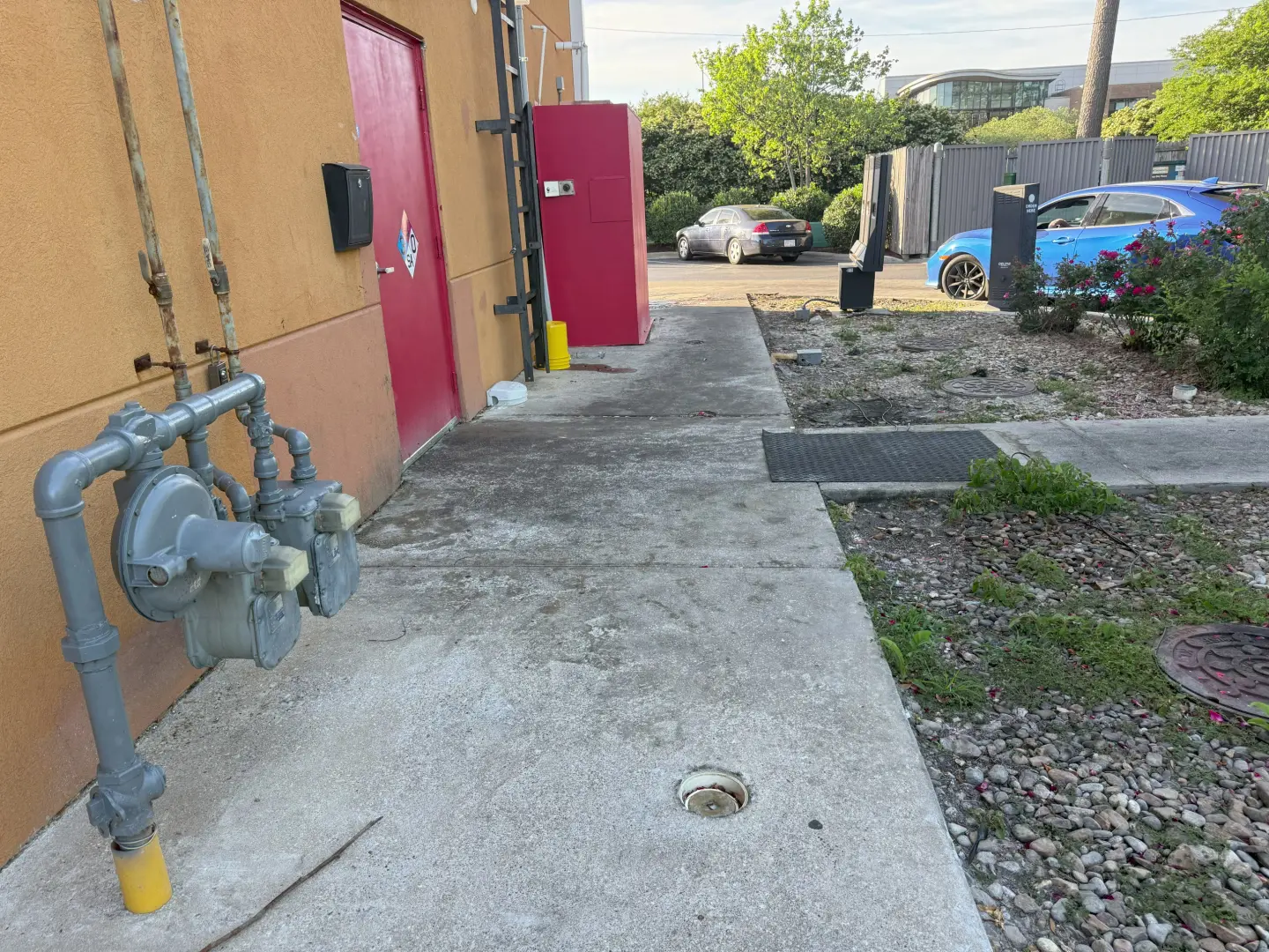 Pressure washing revealed a clean, concrete walkway next to a commercial building, enhancing overall appearance.