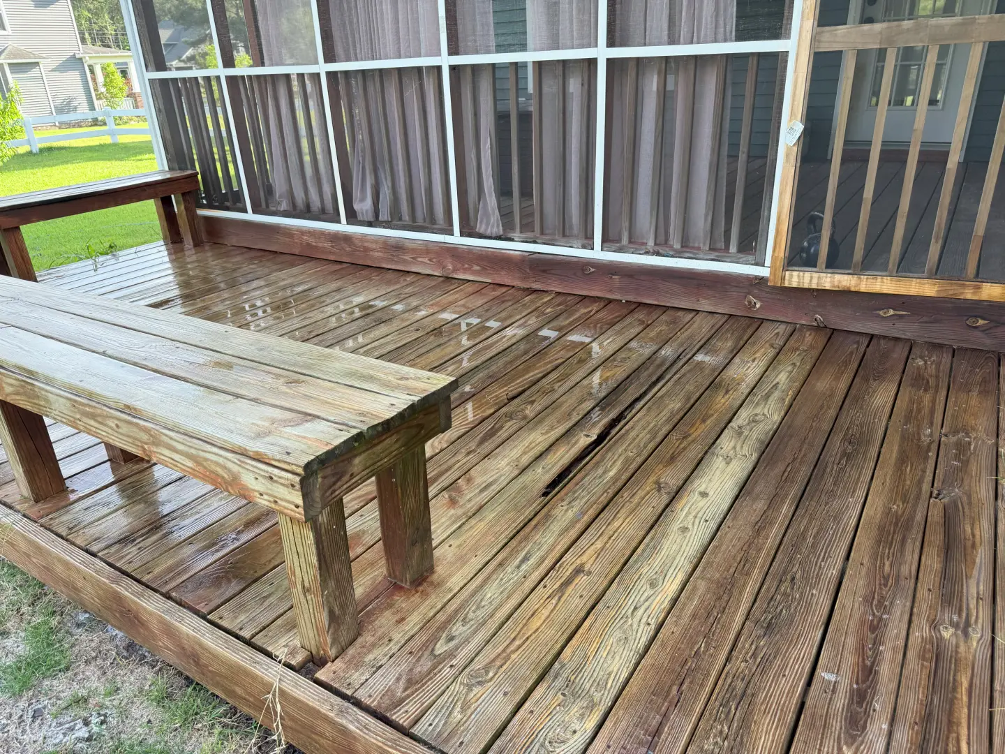 Cleaned wooden deck showcasing a revitalized surface with a noticeable difference in color and cleanliness after pressure washing.