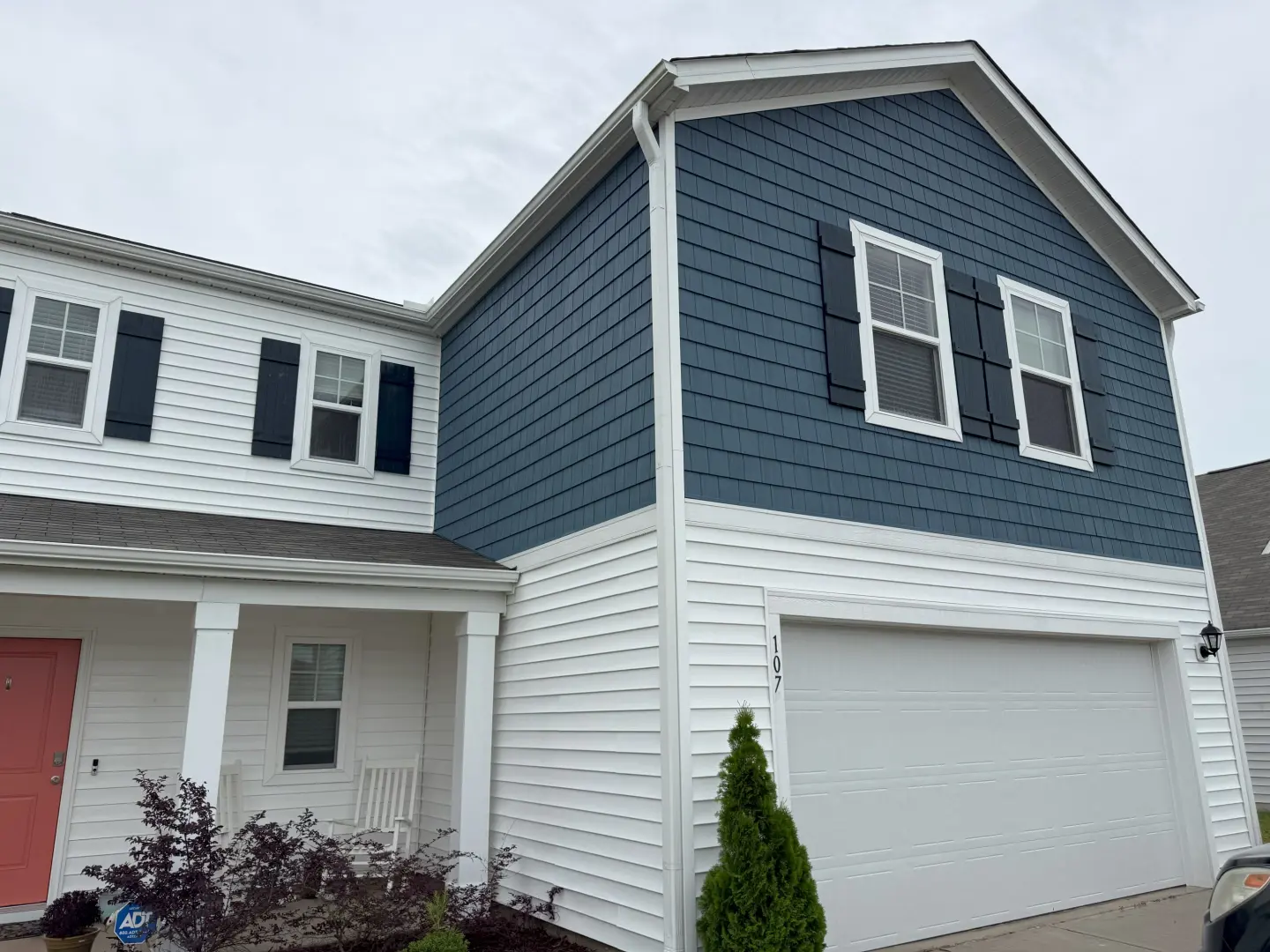Pressure washing a house exterior, showcasing a clean and vibrant blue siding, enhancing curb appeal.