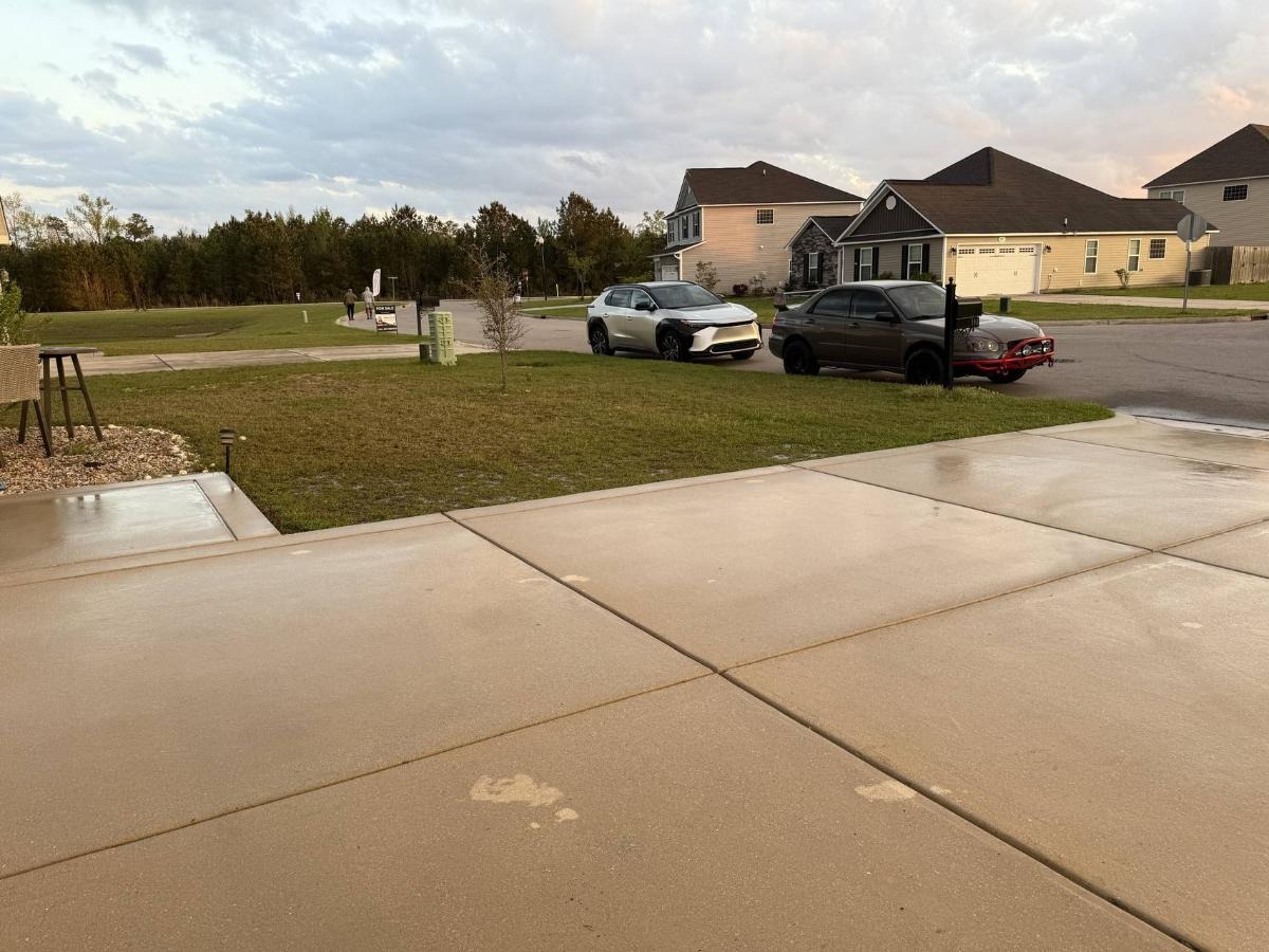 High-pressure concrete cleaning removing oil stains from residential driveway