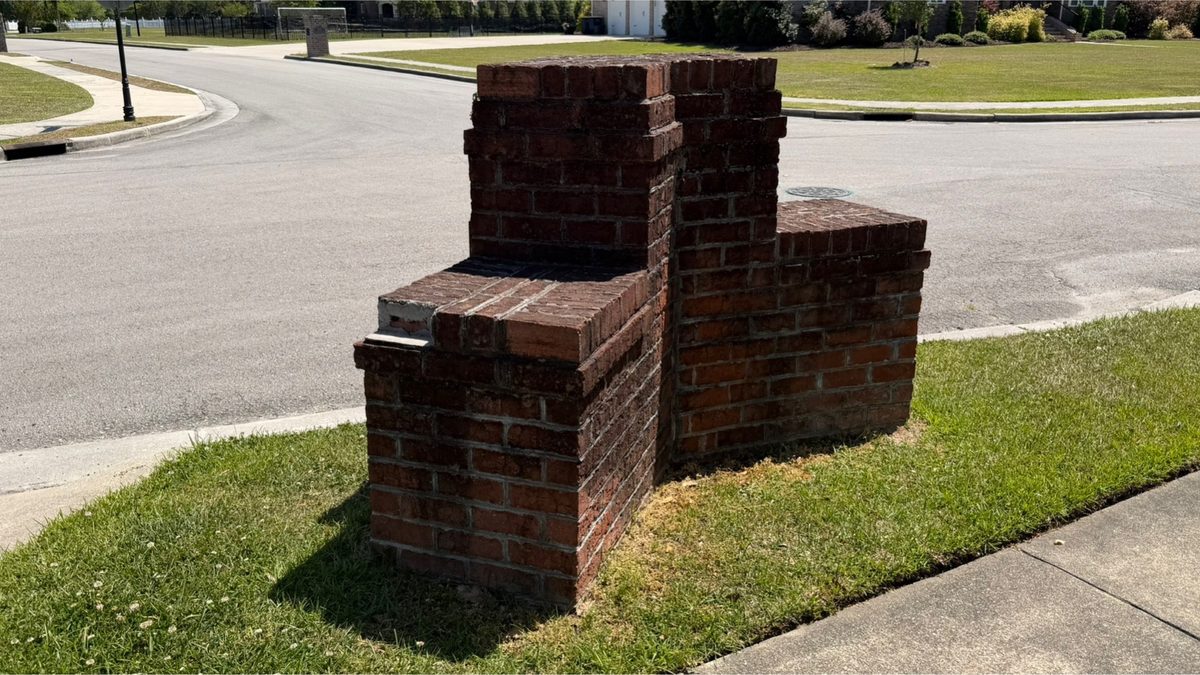 Brick column at a street entrance before cleaning
