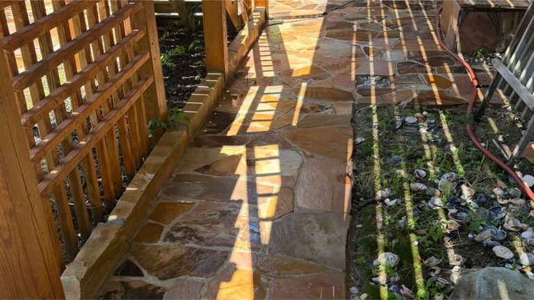 Paver patio under a pergola after cleaning