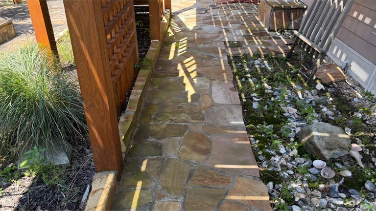 Paver patio under a pergola before cleaning