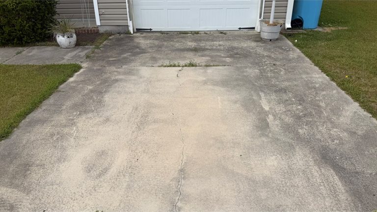 Concrete driveway apron greyed with organic film and traffic marks