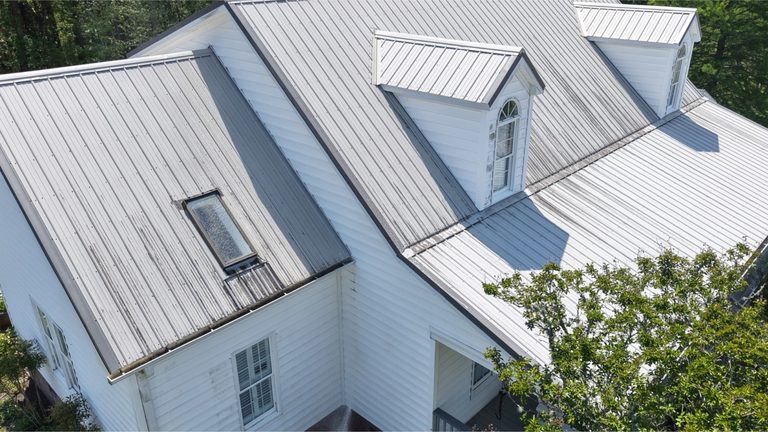 Metal roof with heavy dark streaking across the panels