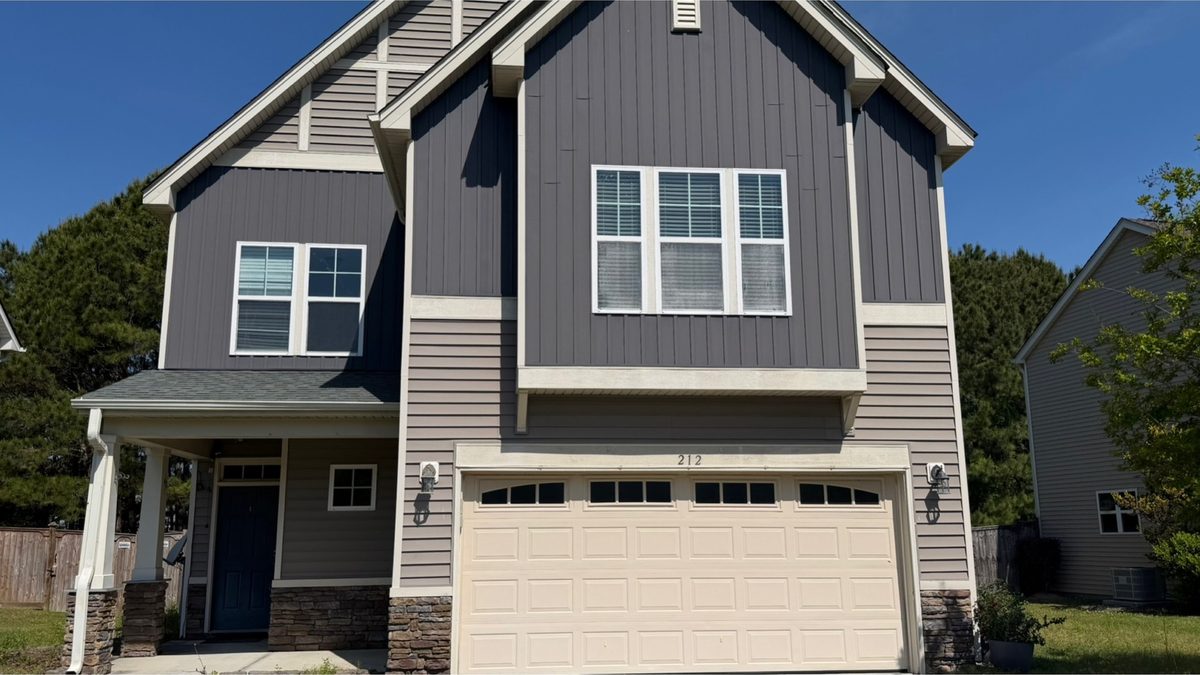 Two-storey home exterior and garage before cleaning