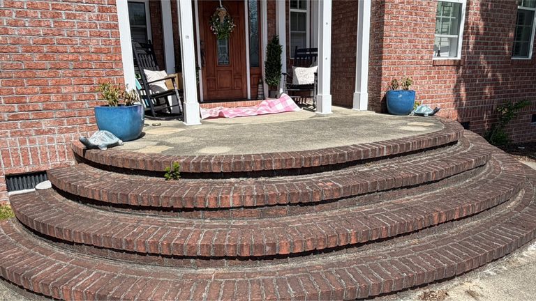 Brick entry steps and concrete treads darkened by organic growth